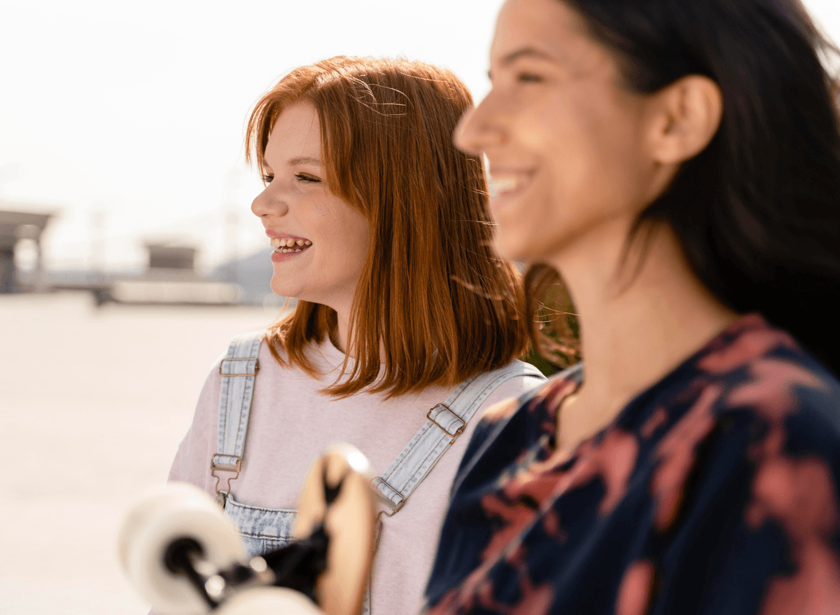 Two women smiling and enjoying a sunny day together, symbolizing hope and recovery through Portland addiction treatment programs