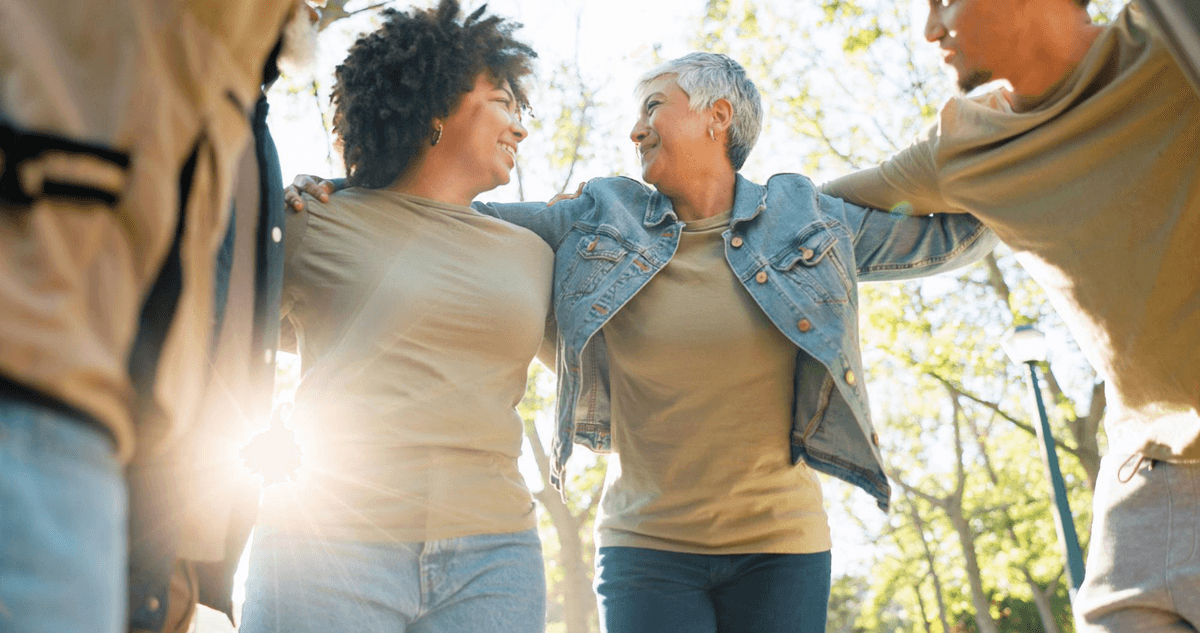 Three friends walking by the river and smiling, highlighting friendship and healing through diverse addiction treatment programs in Portland