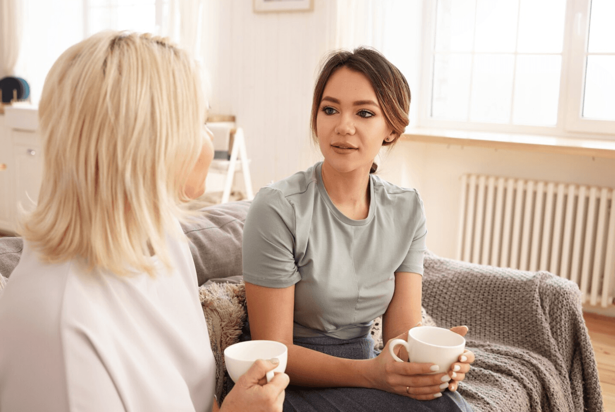 Two women sitting on a couch, engaged in an addiction counseling session to help treat marijuana use